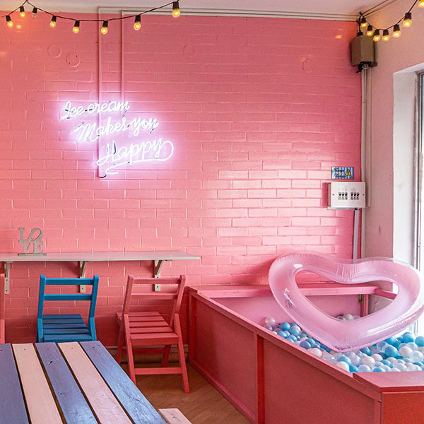 heladeria vintage con piscina de pelotas azul y blanco, pared en ladrillo rosado y flotador de corazon